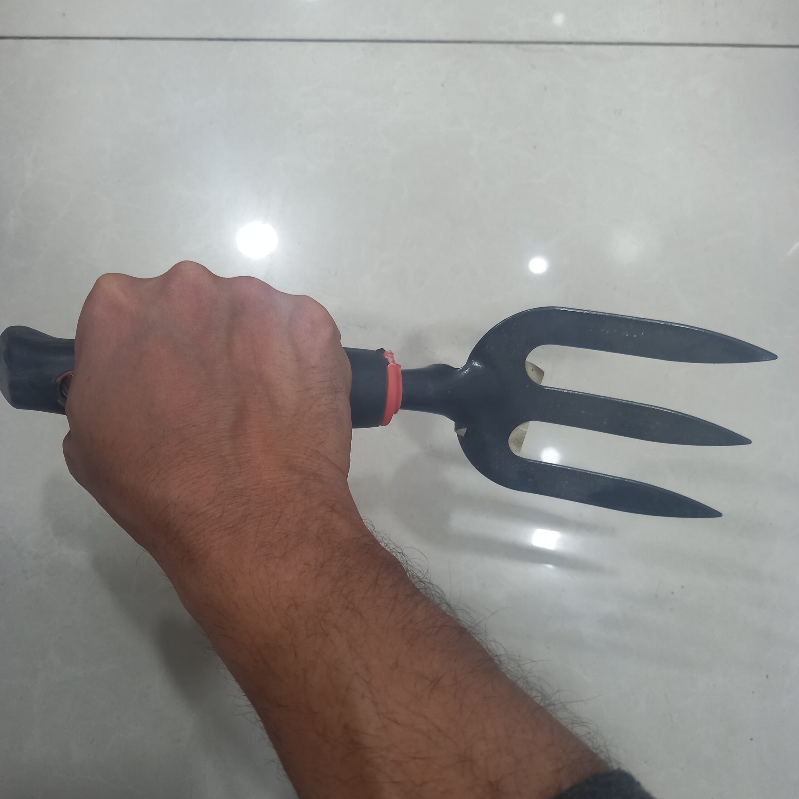 صورة شوكة زراعية يدوية بثلاث أسنان حادة